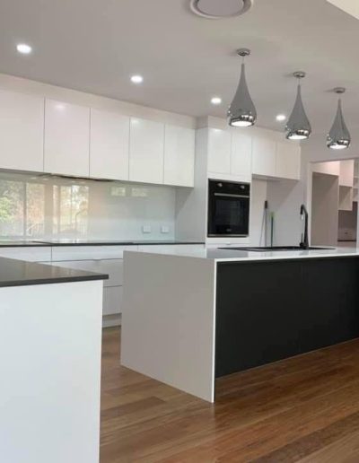 A modern kitchen featuring white cabinets and sleek black countertops